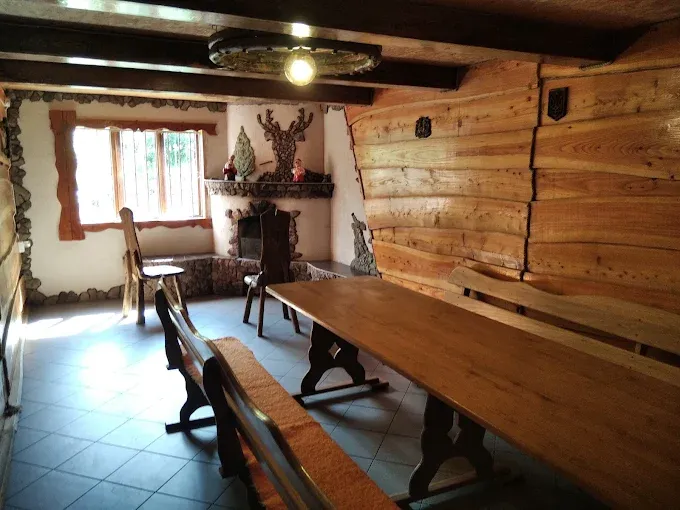 Трапезна з каміном, дерев’яними столами й лавами